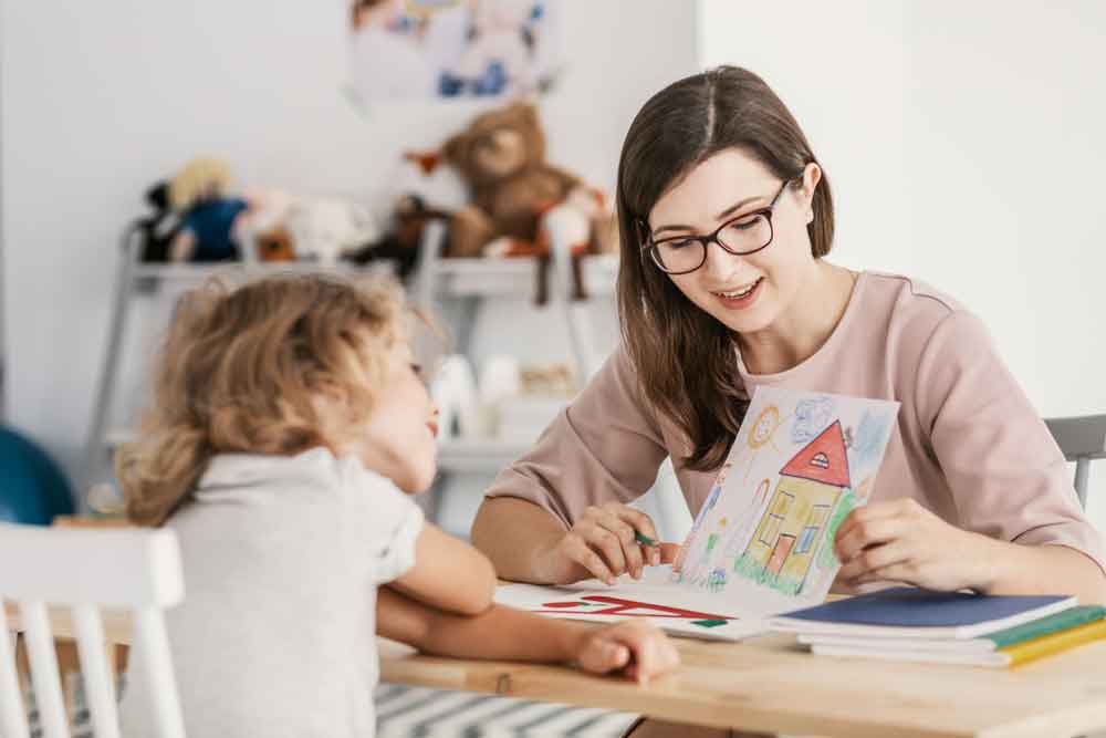 A professional child education therapist having a meeting with a kid in a family support centre