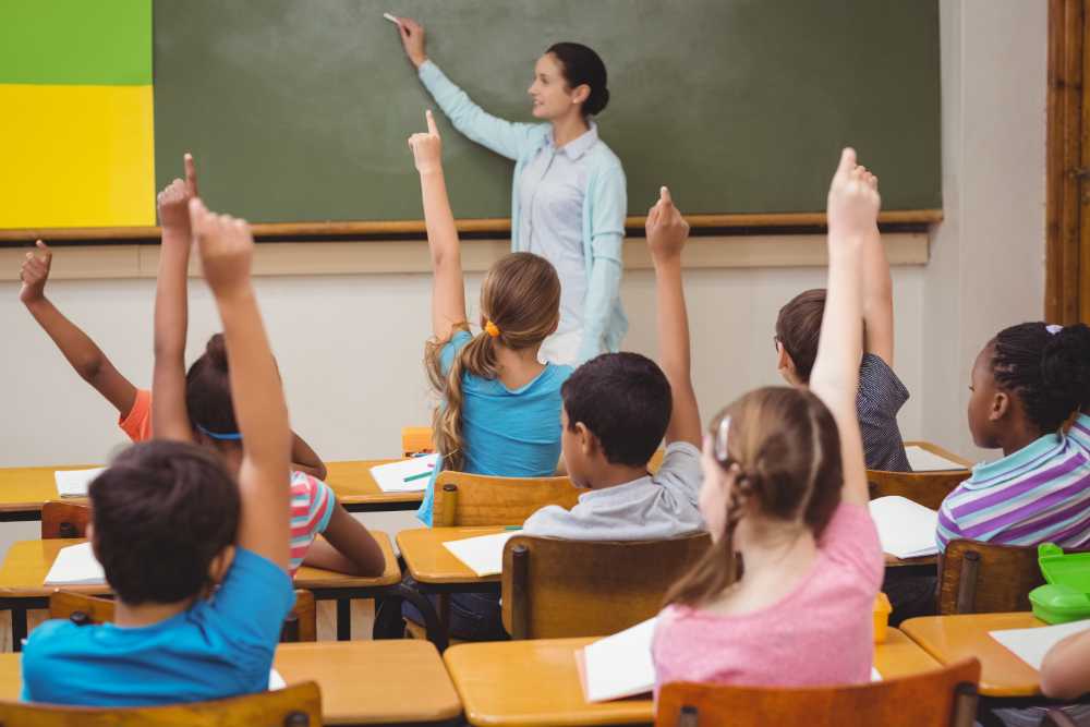 Teacher asking a question to her class at a primary school