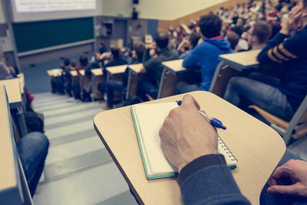 Student in a lecture theatre taking notes