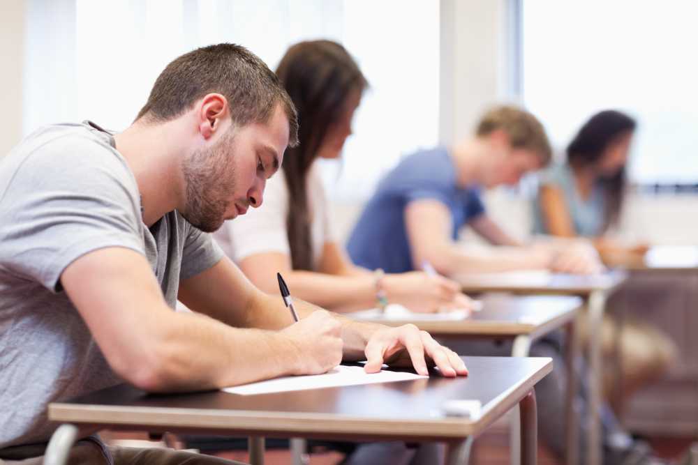 Student writing an assignment in a classroom